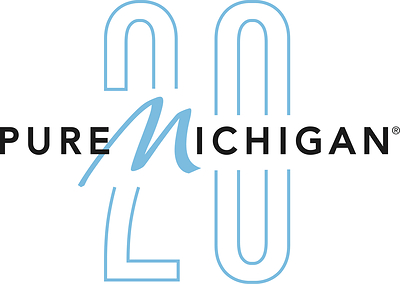 Pure Michigan 20th anniversary logo. The word "Pure" is in black sans-serif type, followed by the word "Michigan." The "M" is in a light blue script with the rest of the word "Michigan" in the same black sans-serif font. A large, stylized number 20 in light blue outlines sits in the background.