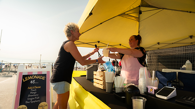 A vistor enjoys a cool refreshment from a mobile food concession at Beach Area 1