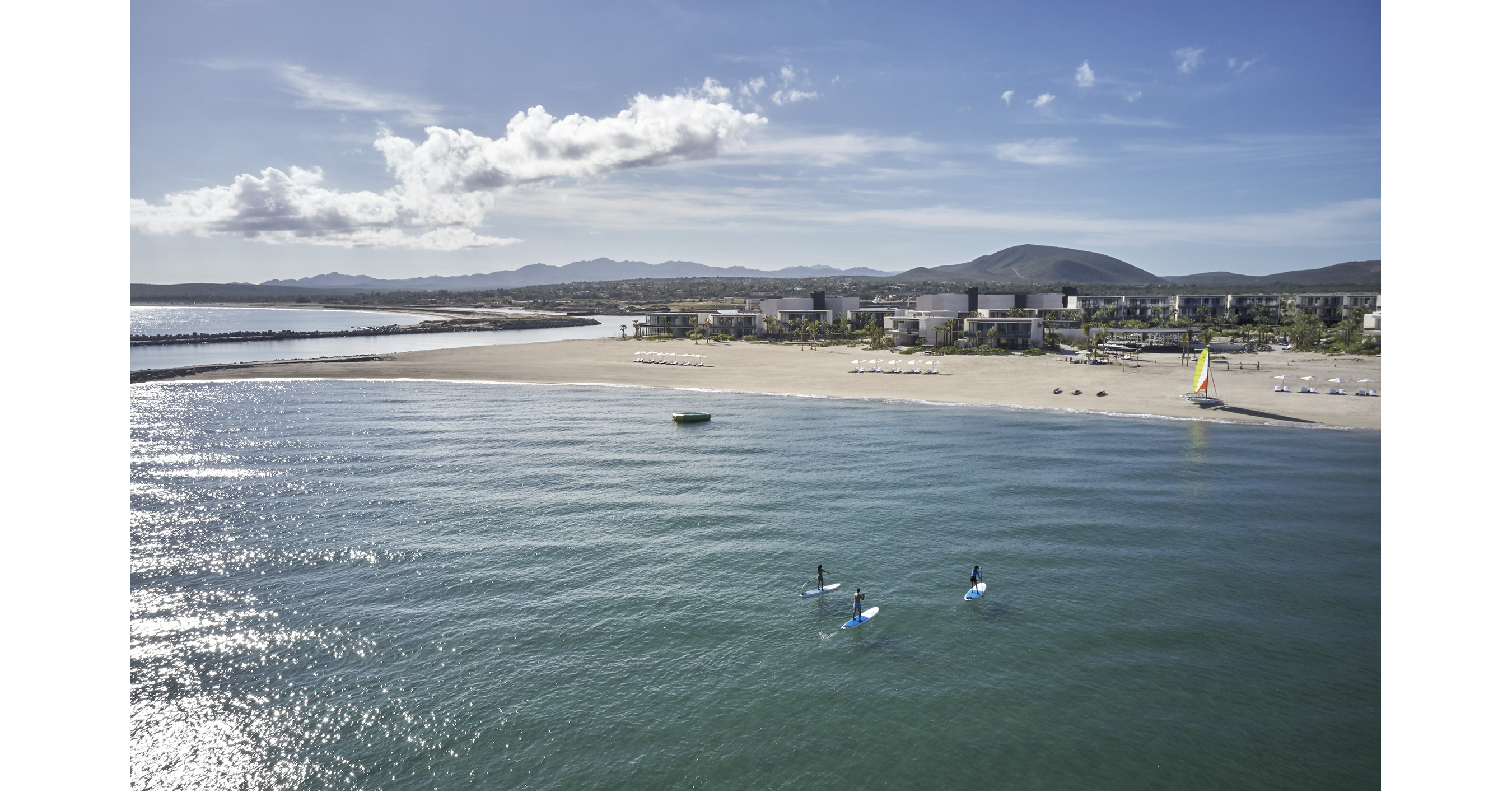 Aerial view of Four Seasons Resort Los Cabos at Costa Palmas, showing beachfront, marina, and resort pools under a sunny sky.