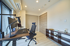 Dedicated workspace with ultrawide monitor and ergonomic desk setup inside an Anyplace apartment in Tokyo.