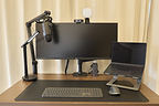 Dedicated workspace with ultrawide monitor and ergonomic desk setup inside an Anyplace apartment in Tokyo.