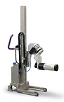 Stainless-steel Packline lifter handling a large pharmaceutical film roll with a motorised 6-inch spindle attachment in a clean, hygienic production environment.