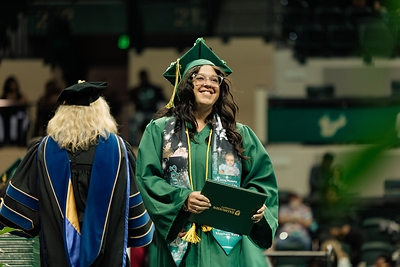 A Rasmussen University graduate crosses the stage during the 2025 Florida Commencement Ceremony at the Yuengling Center in Tampa, Florida, celebrating the culmination of their hard work and academic achievement.