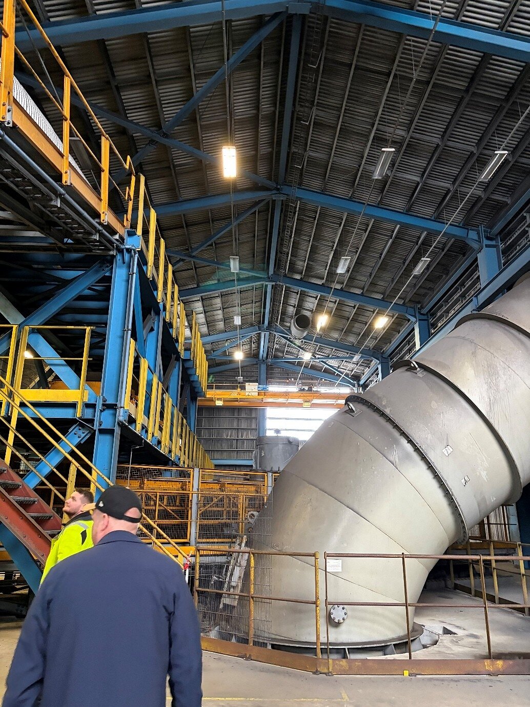 Interior of the former furnace building at Helguvík, showing large scale exhaust ducting and structural steelwork that could be repurposed as part of a modern, low impact processing facility concept. Photo from Greenland Mines Ltd site visit at Helguvik. Interior of the former furnace building at Helguvík, showing large scale exhaust ducting and structural steelwork that could be repurposed as part of a modern, low impact processing facility concept. Photo from Greenland Mines Ltd site visit at Helguvik.