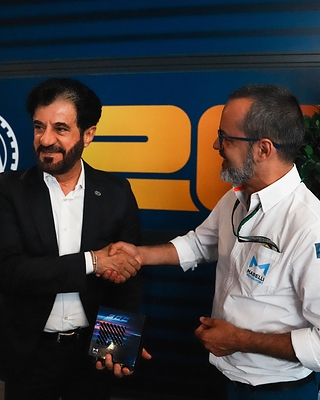H.E. Mohammed Ben Sulayem, President of the FIA, receives a limited edition SDR4 from Riccardo De Filippi, Head of Marelli Motorsport