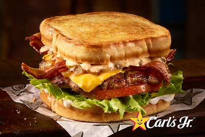 Carl's Jr. Sourdough Star features a charbroiled all-beef patty, two strips of cherrywood bacon, classic sauce, grilled onions, melted American cheese, lettuce, tomato, and mayonnaise on thickly sliced toasted sourdough bread.