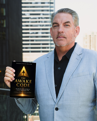 Gordon Charles MacLean, commercial real estate executive, entrepreneur, military veteran, and author of The Awake Code: 39 Rules for a Fully Engaged Life, holds a copy of his debut book ahead of its July 7 Chicago launch event.

Photo Credit: The Awake Code