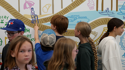 Students explore the Destination Wasaga Imagine Mural, which was inspired by their ideas and contributions.
