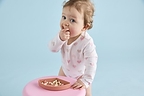 Toddler enjoying Little Bellies Organic Nibblers, made for toddlers 12+ months.