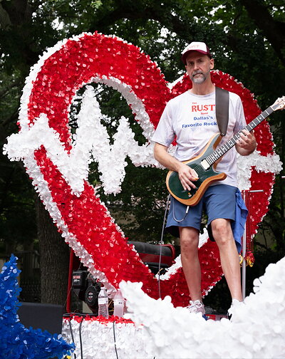 A member of The Rust Band performs atop the Advance ER float during the Park Cities Fourth of July Parade. The band provided live music throughout the parade as Advance ER celebrated Independence Day alongside the Park Cities community.