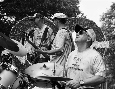 Dr. Pettit of Advance ER performs on drums with The Rust Band aboard the Advance ER float during the Park Cities Fourth of July Parade. 