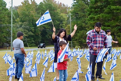 Una familia reza mientras plantando banderas israelíes en la Iglesia Misionera Betel en Commerce, Georgia, como parte del evento Banderas de la Fraternidad en octubre de 2025. Más de 1.350 iglesias, sinagogas y organizaciones participaron en la campaña liderada por el IFCJ el año pasado. Crédito de la foto: Iglesia Misionera Betel
