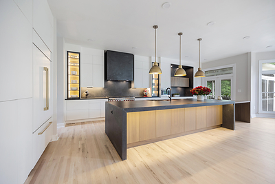 Winner of the 2026 Möbel Best Kitchen Design national award: this open-concept Northern Virginia kitchen remodel by EA Home Design features a 33-foot recessed beam, Wolf and Sub-Zero appliances, Dekton Laos countertops and hood, and custom cabinetry with hidden outlets and interior-lit glass fronts. Photo: EA Home Design, eahomedesign.com