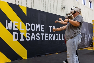 Disasterville, a mixed-reality experience from the Army National Guard, features advanced hand-tracking technology, eliminating the need for game controllers and allowing students to interact with others and physically use in-game props. 