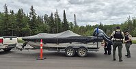 Le personnel de Pêches et Océans Canada et les patrouilleurs des parcs provinciaux du Manitoba inspectent un bateau à la recherche d’espèces aquatiques envahissantes.