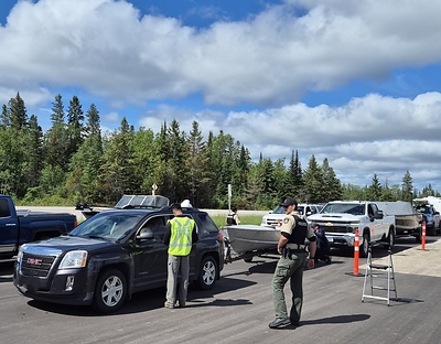 Fisheries and Oceans Canada and Manitoba government staff conduct inspections of eastbound and westbound watercraft along the Trans-Canada Highway just west of the Manitoba–Ontario border.