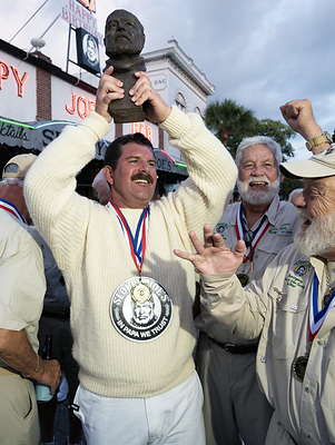 Chris Dutton, surrounded by previous winners of the Hemingway Look-Alike Contest, raises a bust of Ernest Hemingway in triumph after winning the 2026 competition Saturday, July 25, 2026, at Sloppy Joe's Bar in Key West, Fla. The Tampa, Fla., man was the first "young Hemingway" winner in the contest's 45-year history. Drawing 134 entrants, the three-night competition highlighted the island city's annual Hemingway festivities that end Sunday, July 26. Chris Dutton, surrounded by previous winners of the Hemingway Look-Alike Contest, raises a bust of Ernest Hemingway in triumph after winning the 2026 competition Saturday, July 25, 2026, at Sloppy Joe's Bar in Key West, Fla. The Tampa, Fla., man was the first "young Hemingway" winner in the contest's 45-year history. Drawing 134 entrants, the three-night competition highlighted the island city's annual Hemingway festivities that end Sunday, July 26.
