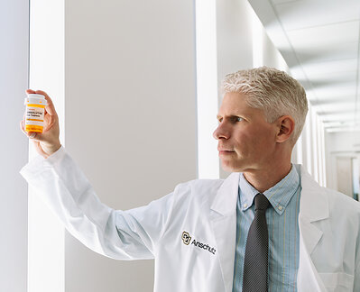 Photo of Joseph Schacht, PhD, at CU Anschutz holding up bottle of semaglutide 