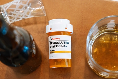Photo of semaglutide bottle with beer bottle and glasses of alcohol 
