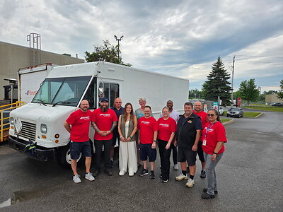 Des membres de l’équipe de Purolator se joignent aux représentants de Kawartha Lakes Food Source à Lindsay en Ontario pour souligner le don d’un camion de livraison retiré du service. Le don d’un camion de livraison retiré du service.