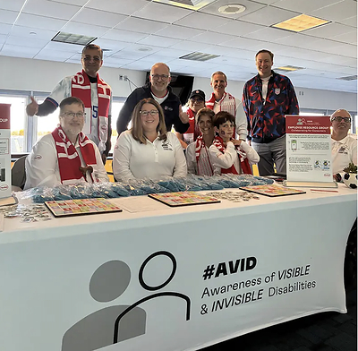 Members of Henkel’s Awareness of Visible and Invisible Disabilities (AVID) Employee Resource Group host a resource table featuring sign language and educational materials at the company’s Match and Mixer employee event.