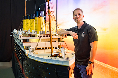 Director Tom Rudderham by an 18-foot model of the Titanic.
