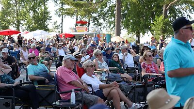 A large crowd relaxes in lawn chairs while enjoying a free outdoor music festival in Wasaga Beach.