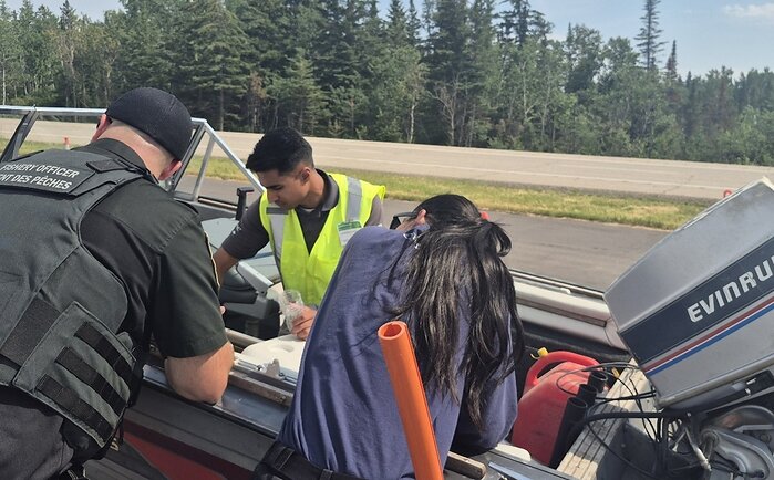 Le personnel de Pêches et Océans Canada et du gouvernement du Manitoba inspectent un bateau pour détecter la présence d’espèces aquatiques envahissantes.