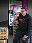 Jeremy J. Petersen, Founder, President & CEO of Identity Pet Nutrition, with his dog Zoey in front of the company’s product portfolio. Photo courtesy of Identity Pet Nutrition.