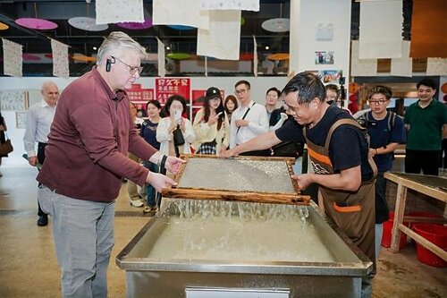 H.E. Mr. Karlis Eihenbaums，ambassador of Latvia to China, tries his hand at the traditional craft of Xuan papermaking.