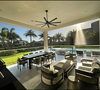 Fenetex MaxForce Retractable Hurricane Screens surround a residential patio that overlooks palm trees and a swimming pool