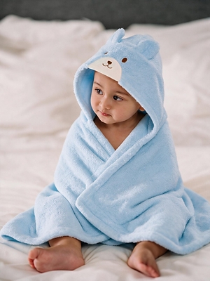 Little Luxuries by MIKI HOUSE at The Ritz-Carlton, Bali. A baby wears the premium MIKI HOUSE bath poncho, crafted from 100% cotton to keep little ones warm and comfortable after every bath or swim.