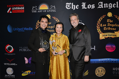 From left: producer Sir Daniel K. Winn, whose childhood inspired the biographical drama Chrysalis; actress Kieu Chinh; and executive producer Randall J. Slavin with the film's awards at the 2026 Los Angeles Tribune International Film Festival in Culver City, California.