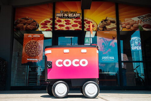 Coco delivery robot outside a Little Caesars restaurant.