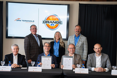 APM Terminals and Orange EV representatives at the agreement signing. Front row, left to right: Bill Hamlin, Kurt Neutgens, Henrik Kristensen and Mark Nolet. Back row, left to right: Sim Whitehill, Debra Paul and John Haake.