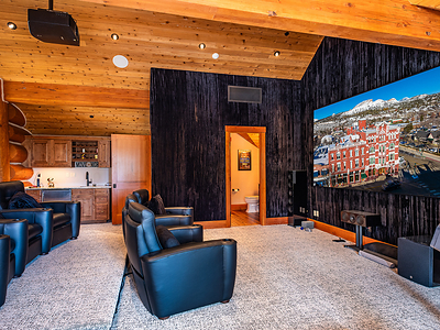 The upper-level home theater features a projection screen, wet bar, half-bath, sound-dampening wall treatments and theater chairs with synced motion and vibration functions for an enriched viewing experience. DurangoLuxuryAuction.com.