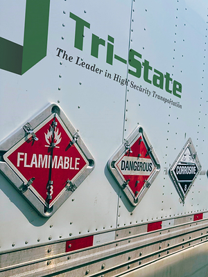 A Tri-State Motor Transit hazardous materials trailer displays required hazmat placards.
