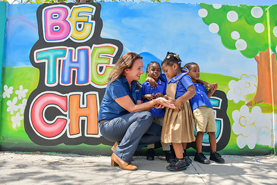 Heidi Clarke, Executive Director of the Sandals Foundation and 2026 Skift IDEA Awards Trailblazer winner, connects with students in front of a community mural in Montego Bay, Jamaica. 