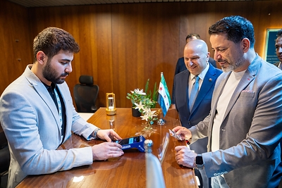 Governor of the Central Bank of Syria, HE, Mohammed Safwat Raslan (extreme right) conducts the first international card transaction using a Mastercard card, marking a significant milestone in reconnecting Syria to the global payments network
