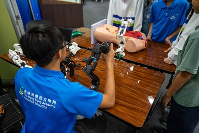 Student members operate an AI robotic arm designed by senior students to identify and move objects.