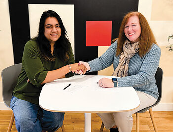 Robbie Adair, CEO of OS Training LLC, and Vinitra Swamy, CEO of Scholé AI, sign partnership agreement.