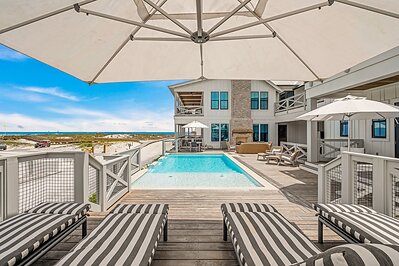 Expansive porches extend from bedrooms and common areas, framing immersive views across native dunes, coastal vegetation, and the gulf beyond. These outdoor spaces feel less like balconies and more like open-air rooms, creating a natural connection between the home and its setting at Grayton Beach. 