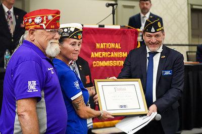 Accepting the award on behalf of 1st Place Post 103 Punta Gorda, The American Legion Department of Florida, are Past District Commander Michael "Gambler" Raymond (left) and District 13 Commander Laurene Flower. 1Nation President Charles Fowler (right) presents the award.