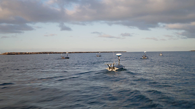A fleet of Seasats Lightfish unmanned surface vessels (USVs) transits offshore during maritime operations.