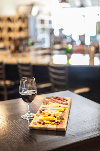 Glass of wine with cheese pairing on charcuterie board