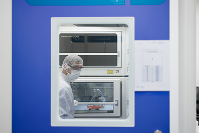 A Viralgen laboratory team member retrieving an Erlenmeyer flask from the incubator.