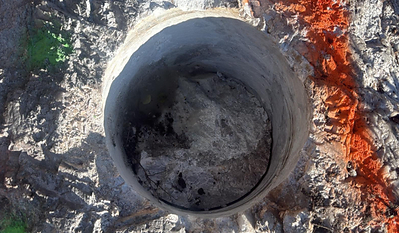 Figure 2: (TOP) Cored drill hole (~30 cm diameter) in pollucite pegmatite outcrop; (BOTTOM) Grid of cored drill holes (~30 cm diameter) in pollucite pegmatite outcrop (see Table 1). Segments between holes are jackhammered out and added to sample composite. Figure 2: (TOP) Cored drill hole (~30 cm diameter) in pollucite pegmatite outcrop; (BOTTOM) Grid of cored drill holes (~30 cm diameter) in pollucite pegmatite outcrop (see Table 1). Segments between holes are jackhammered out and added to sample composite.