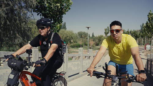 Jerry Grey chats with a local cycling enthusiast as they rode together through urban Kashi on July 17 (EMRAN MAVLAN) Jerry Grey chats with a local cycling enthusiast as they rode together through urban Kashi on July 17 (EMRAN MAVLAN)