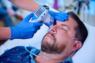 A John Muir Health critical care nurse uses pupillometry to assess a patient’s neurological status.
