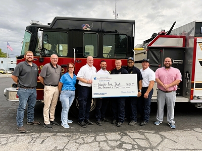 Check photo with Missouri American Water employees and Neosho Fire Department staff. 